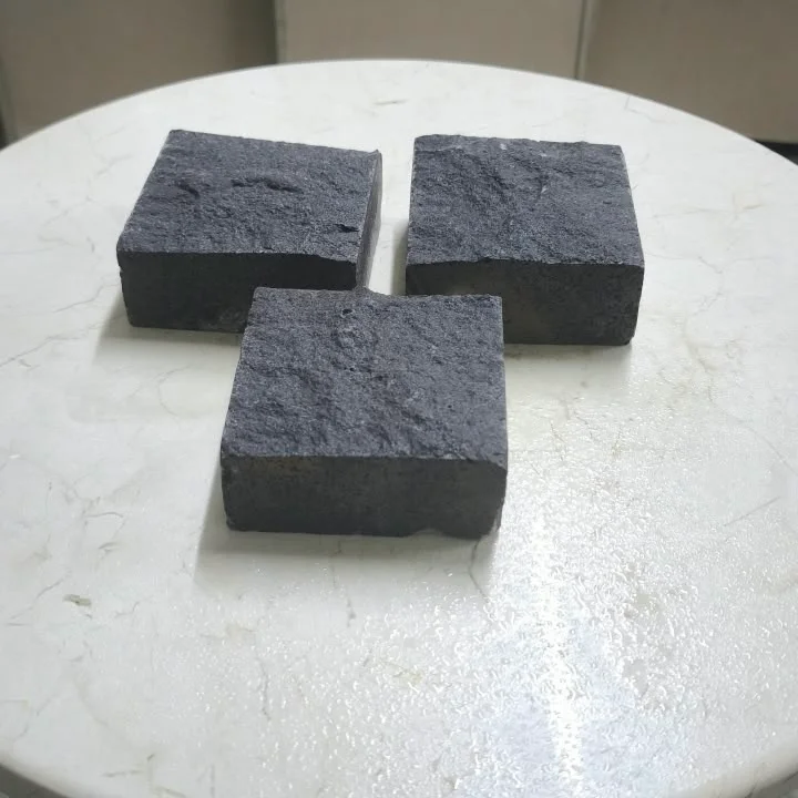 بازلت أسود مفجر (بوشارده): ثلاث قطع مقاس 10×10 سم على طاولة