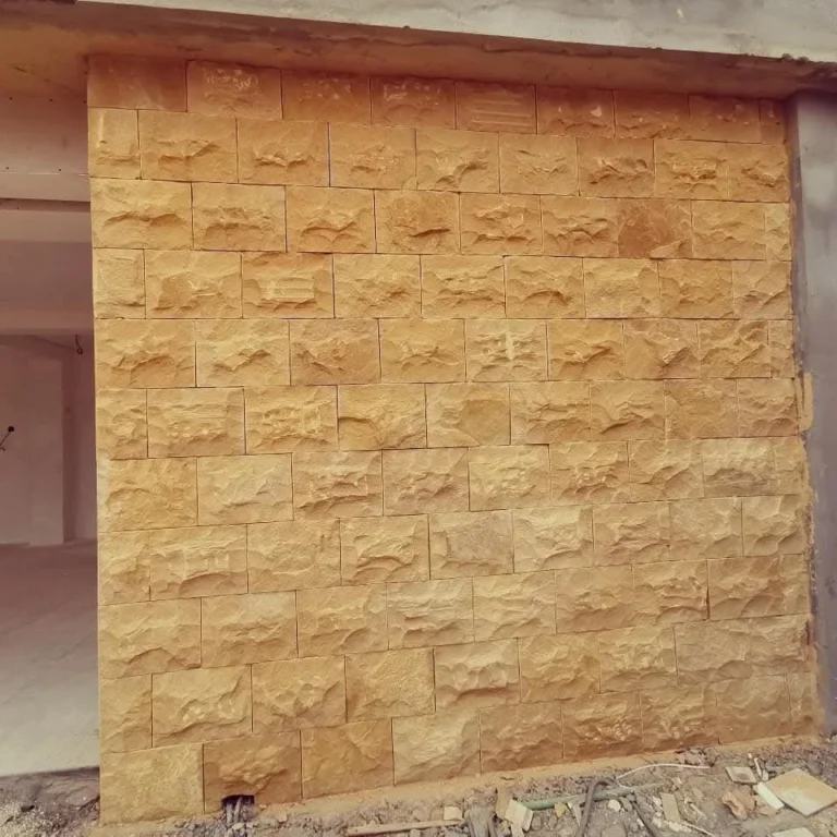 جدار مكسو بحجر منحوت أصفر في مشروع قيد التنفيذ
